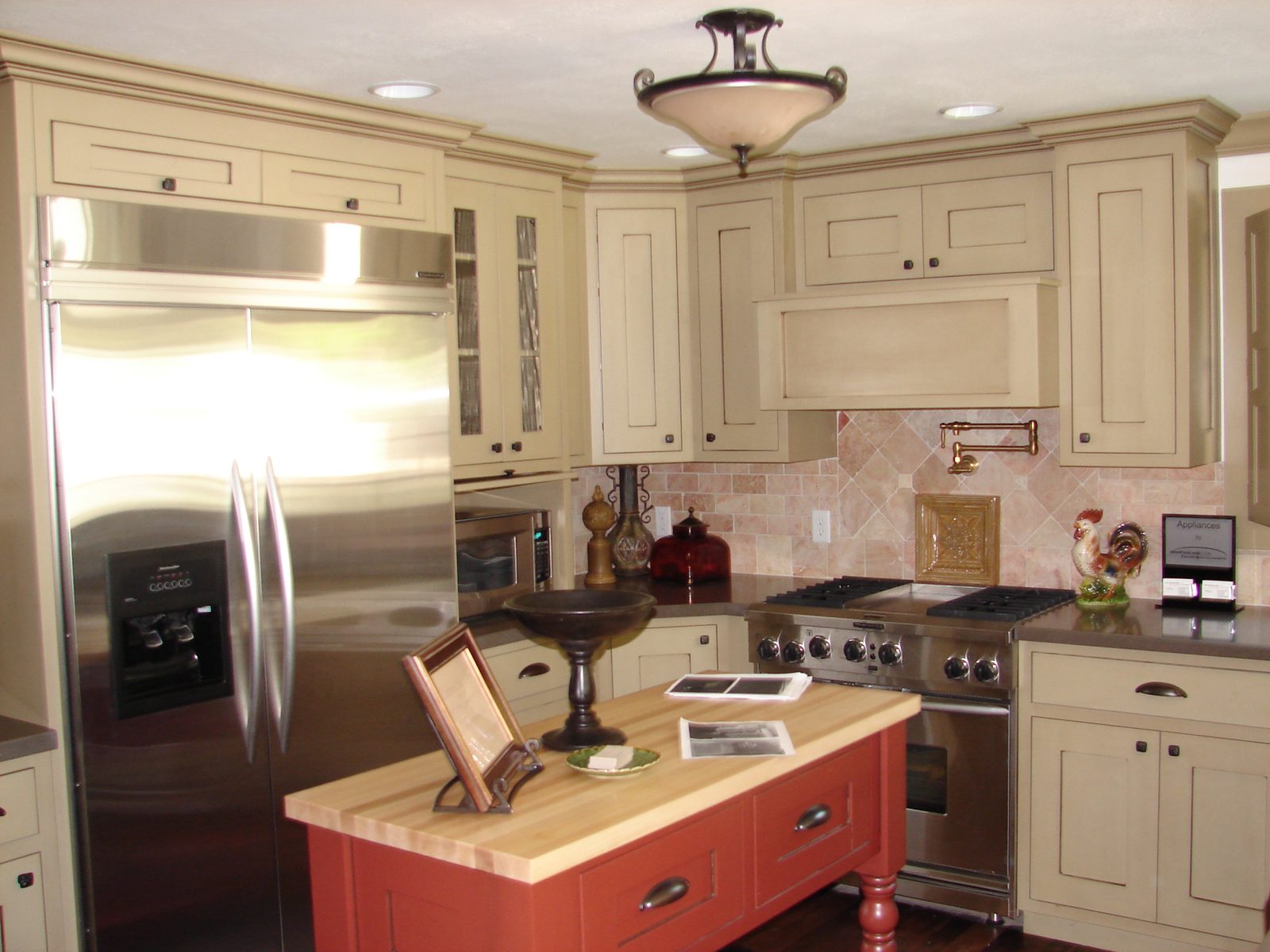 Renovated kitchen with cream cabinets, stainless appliances and a painted island