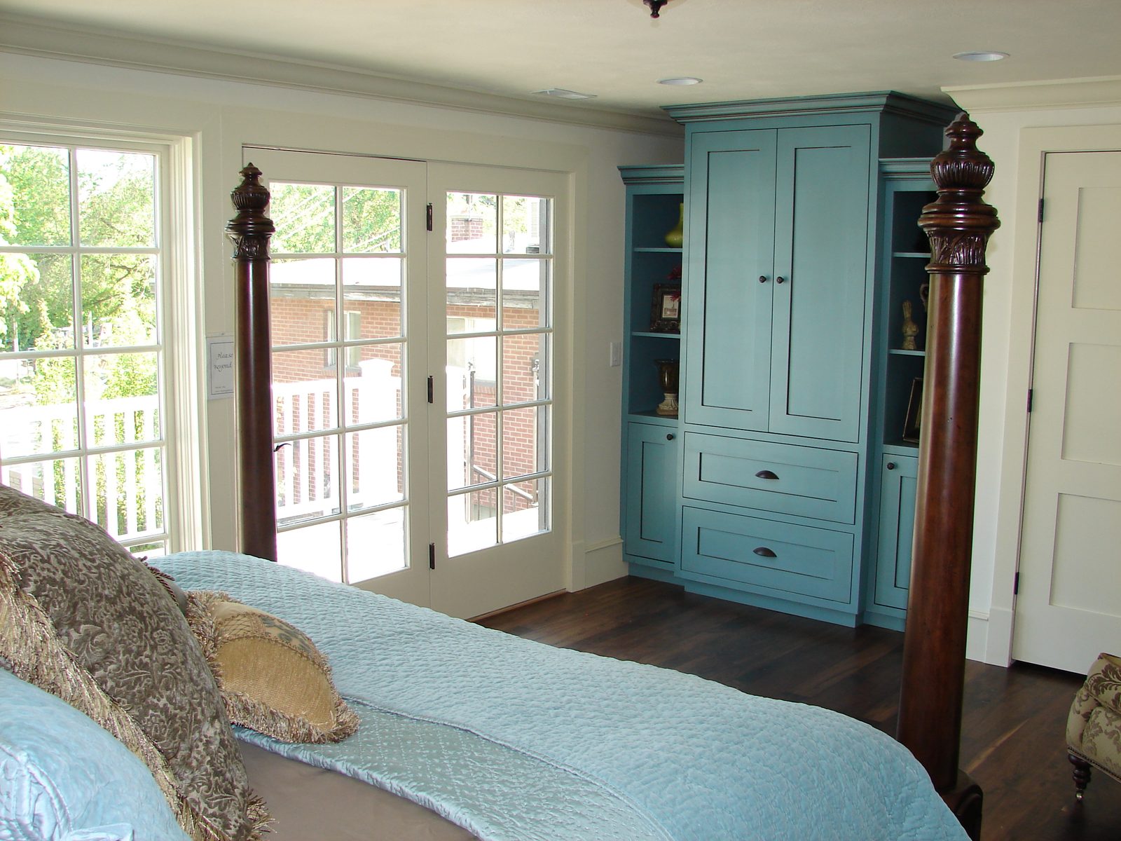 Primary bedroom with french doors and a painted built-in cabinet