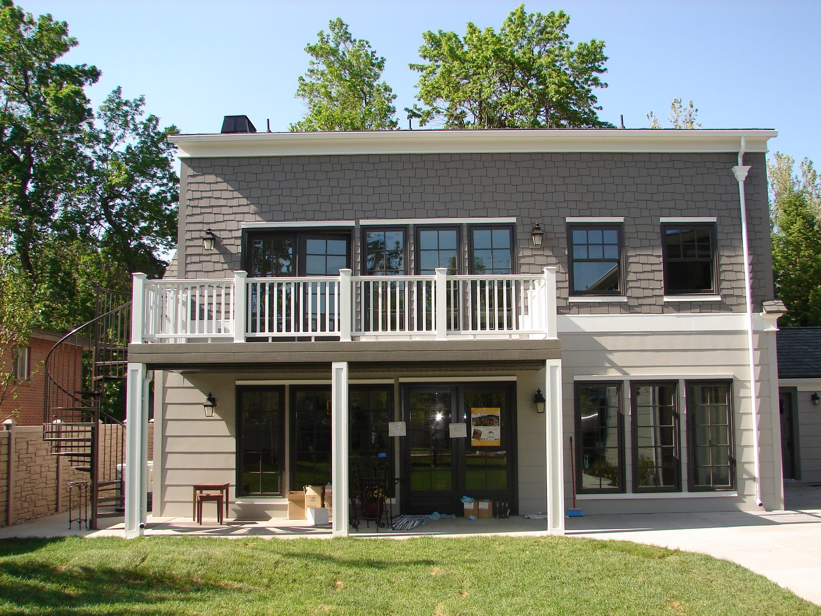 Rear of the home after renovation with a covered porch and second-floor deck