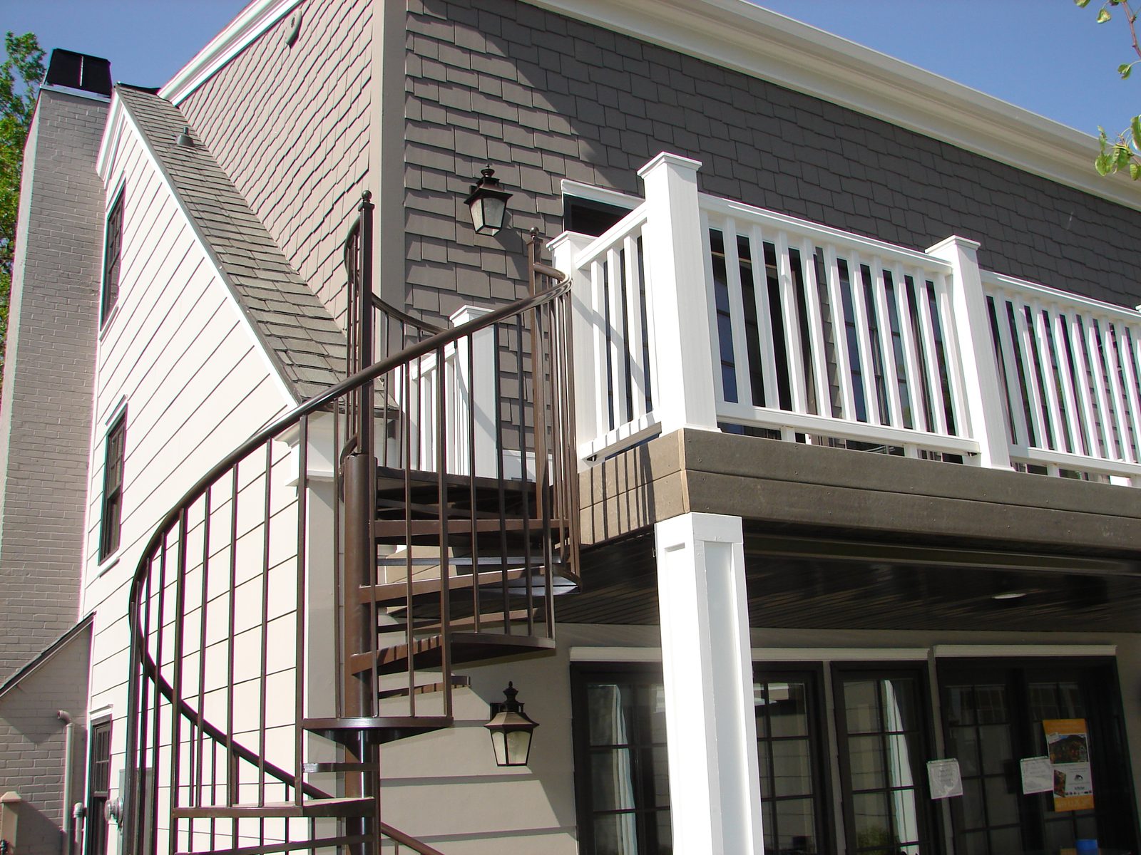 Exterior spiral staircase connecting a deck to the yard