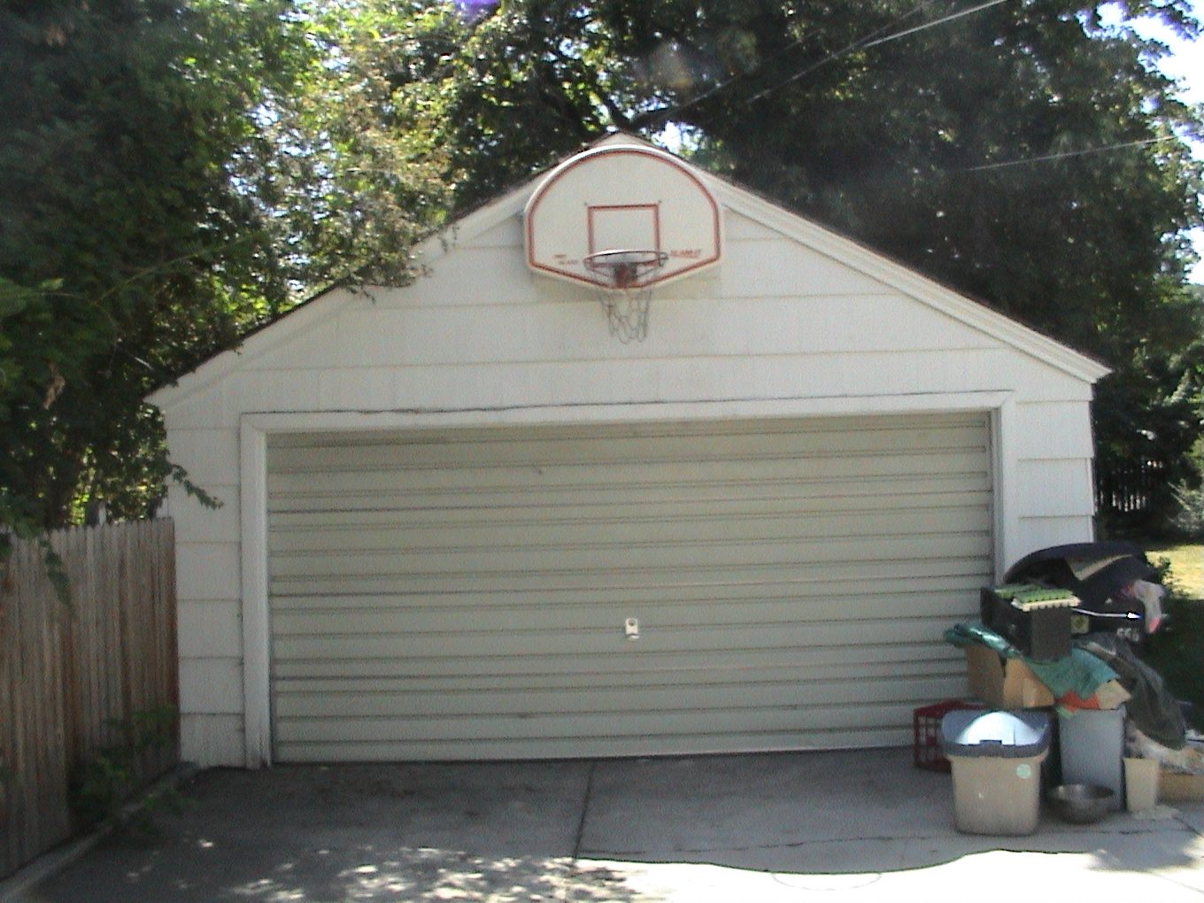 Detached garage before renovation with a basketball hoop above the door