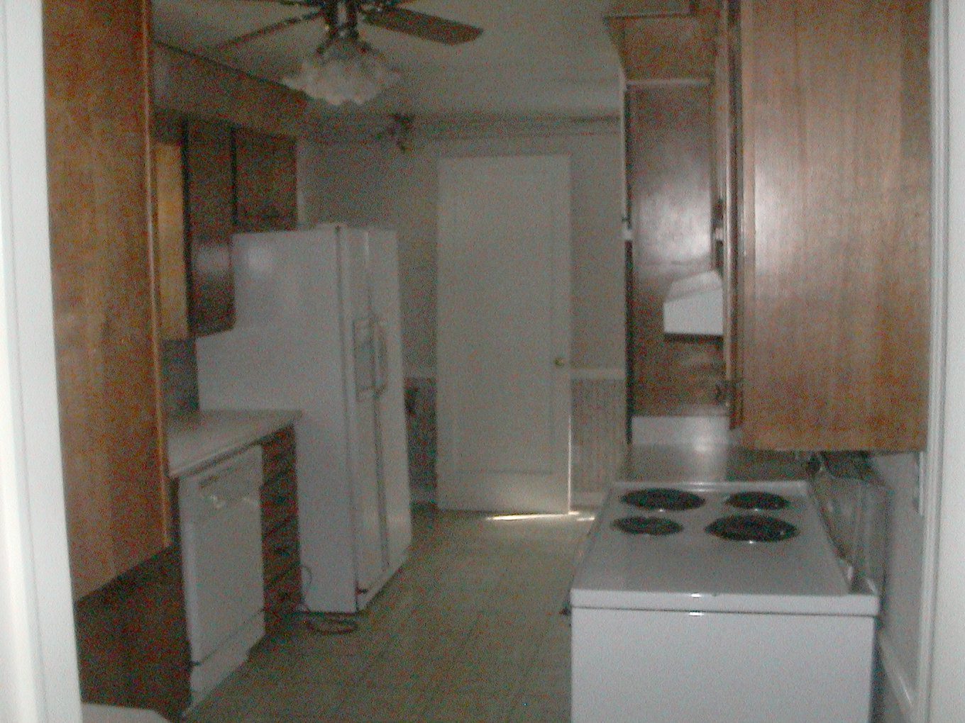 Dated kitchen before renovation with wood cabinets and vinyl flooring