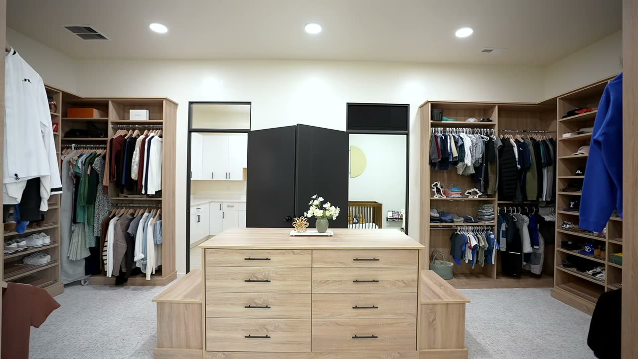 Walk-in closet with built-in cabinetry on three walls and a center island
