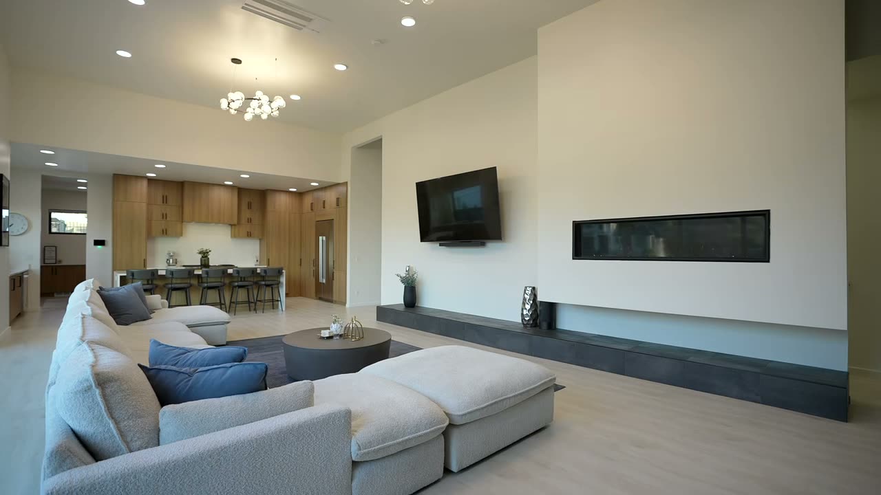 Great room with a linear fireplace, open to the kitchen beyond