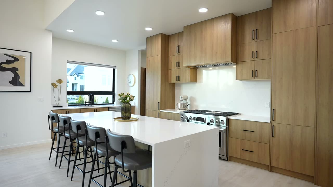 Kitchen with white oak cabinets, a white waterfall island, and bar seating