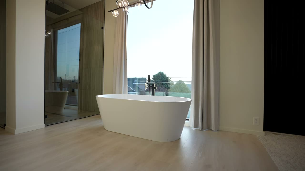 Primary bathroom with a freestanding tub in front of a full-height window