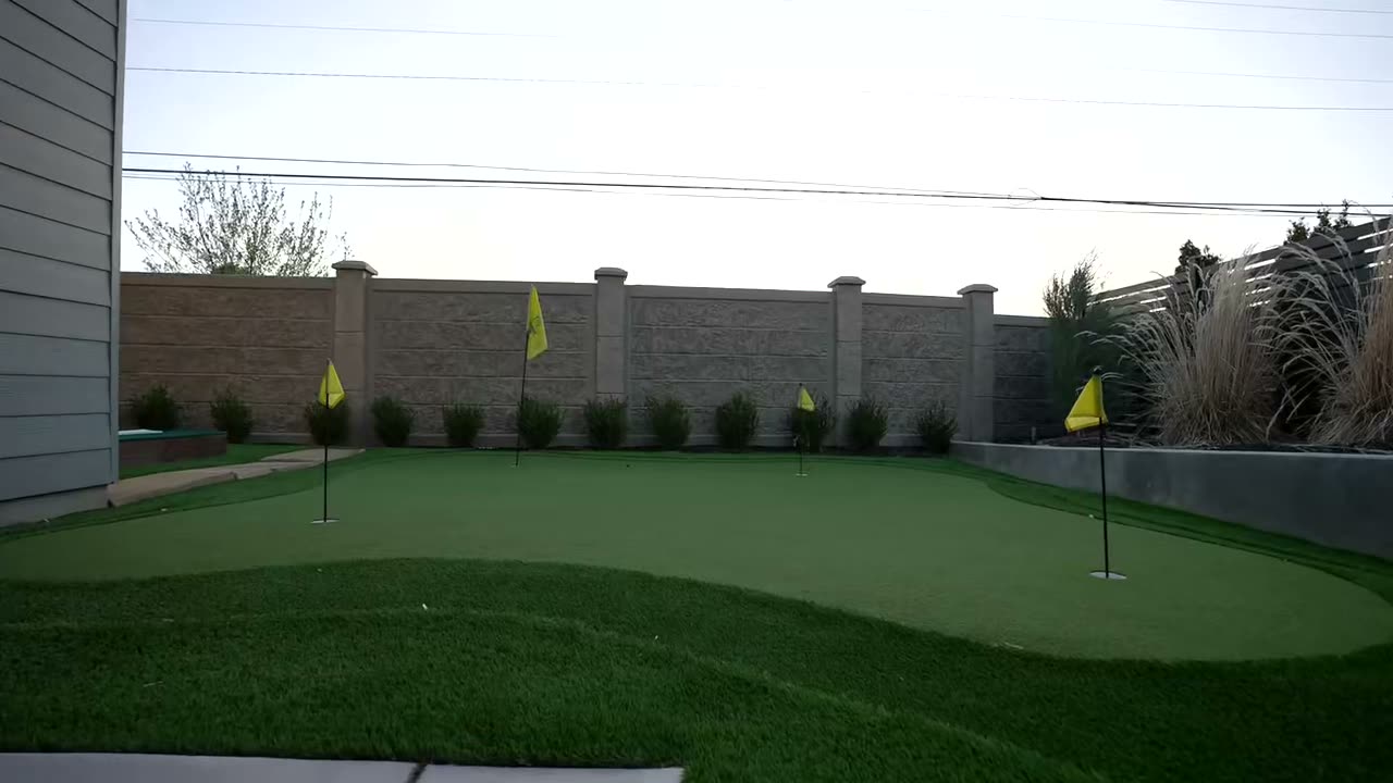 Back yard putting green with flagged holes and turf