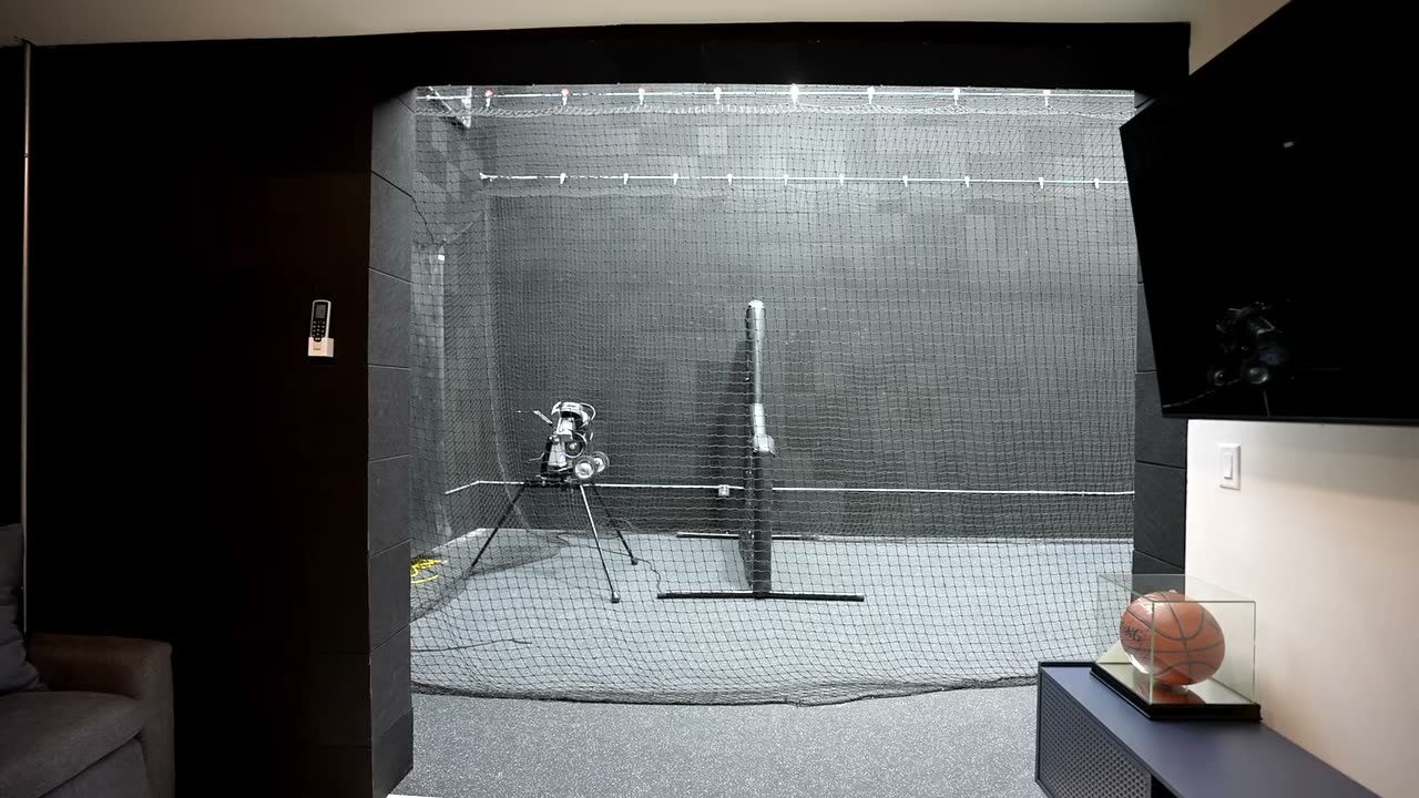Indoor netted sport court with a basketball hoop