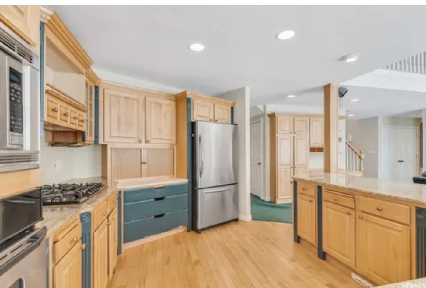 Oak cabinets, teal counters, and a cramped galley kitchen before the renovation