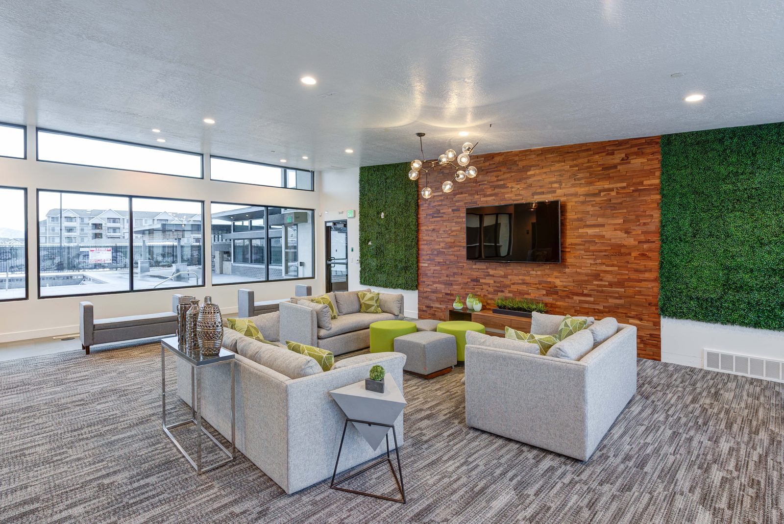 Clubhouse seating area at The Vine with a brick accent wall and a wall-mounted television