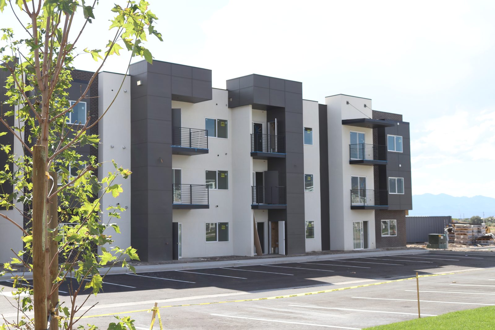 A three-story apartment building at The Vine in daylight with a dark and light paneled facade